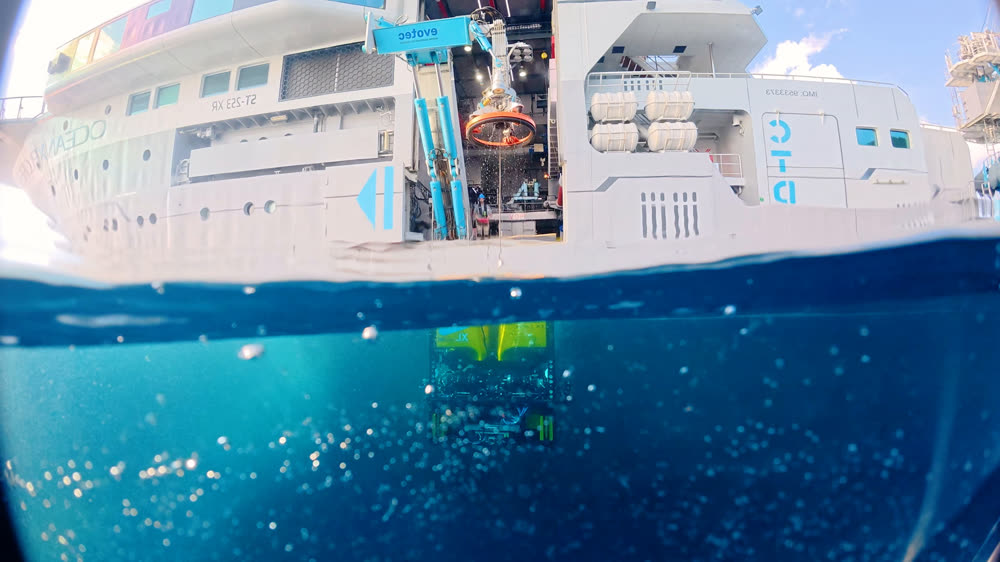 The waterline cutting across the hull of the ship, reef water visible below